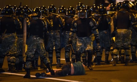 A man lies on the ground in front of riot police during a protest in Minsk on Sunday.
