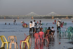 Families gather by the shallow waters of the Nile River at Tuti island in Khartoum, where the Blue Nile and the White Nile meet to become the Nile river