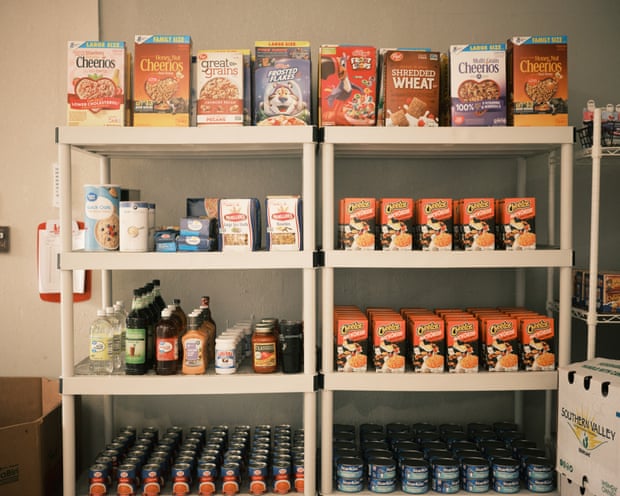 The shelves are completely lined with neat rows of cereals, boxes of pasta, jars of sauce and canned goods.