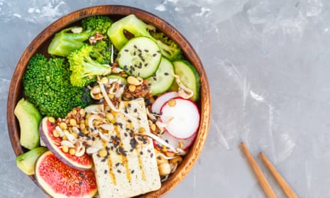Buddha bowl with tofu, broccoli and vegetables in a wooden bowl