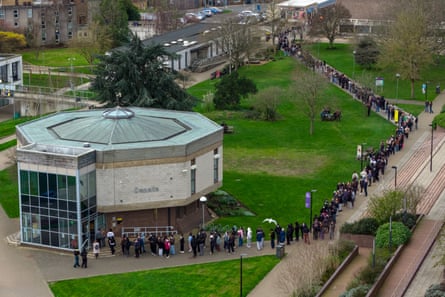 View from high showing long queue snaking out of campus sports hall