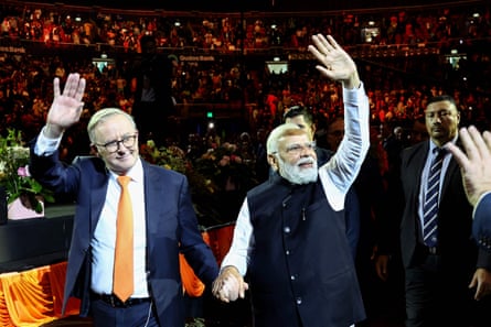 Narendra Modi (R) and Anthony Albanese wave as they leave from an event with members of the local Indian community at the Qudos Arena in Sydney