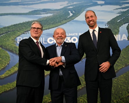 The three shake hands and smile for photos