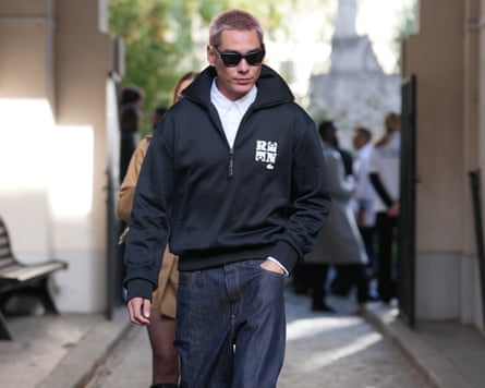 Evan Mock at Paris fashion week in 2025, wearing a quarter-zip and sunglasses.