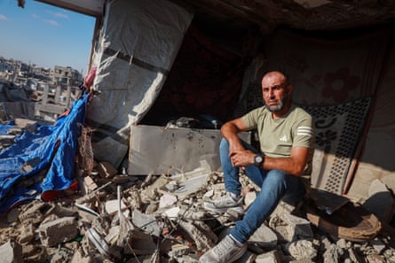 A man sits in the rubble of a building