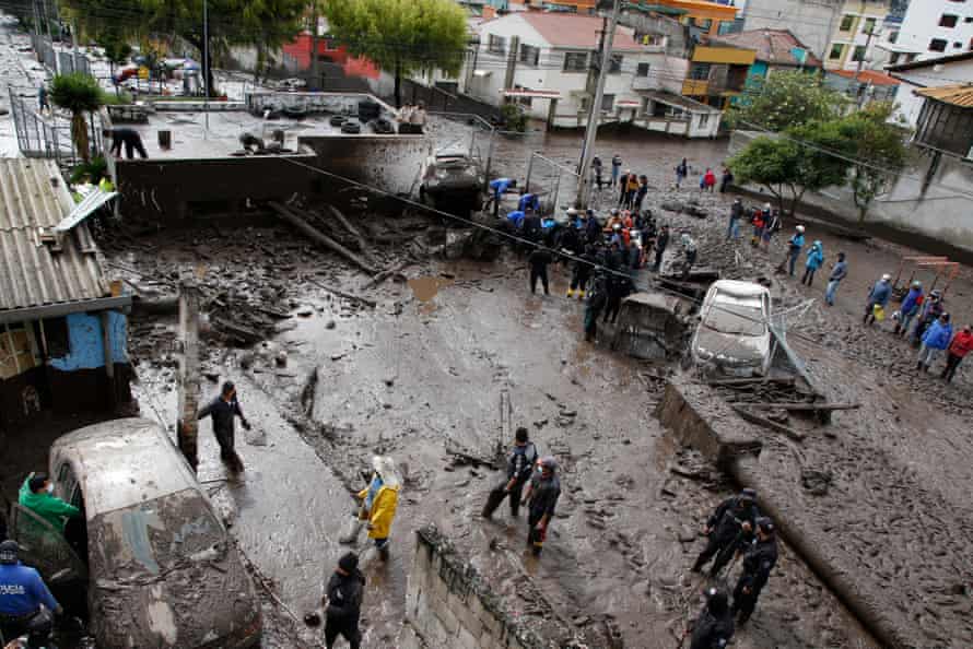 Petugas penyelamat menyaring lumpur yang ditinggalkan oleh tanah longsor di Quito.