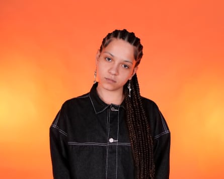 A young woman in a black jacket staring at the camera