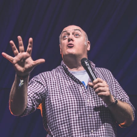 Ó Briain gesticulates on stage, holding a microphone in his left hand