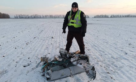 A police officer stands next to part of a Russian cruise missile shot down by the Ukrainian air defences in the Kyiv region earlier this month