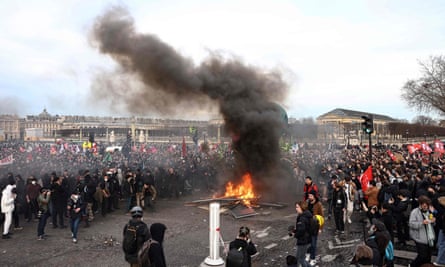 Protesters stand around burning barriers during a demonstration on Place de la Concorde.