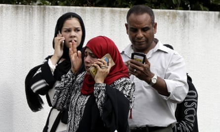 People call family and friends outside a mosque in central Christchurch in the aftermath of the shooting