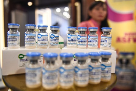 A staff member stands behind vials of African swine fever vaccine for pigs during a presentation of the vaccine in Vietnam in June 2022.