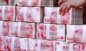 Stacks of 100-yuan banknotes. China has signalled that it will slow the pace of its transition to a cashless society