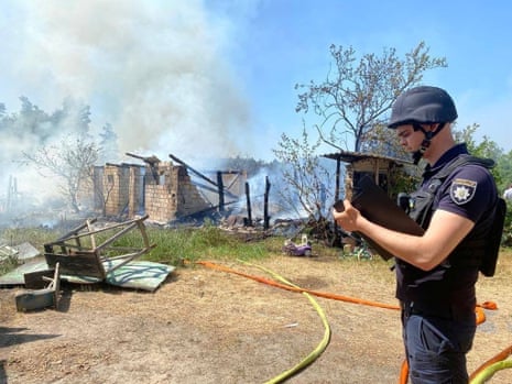 A police officer inspects damage after Russian strikes in Kyiv region.
