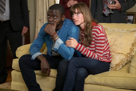Allison Williams comforts Daniel Kaluuya while they sit on a yellow-and-gold sofa