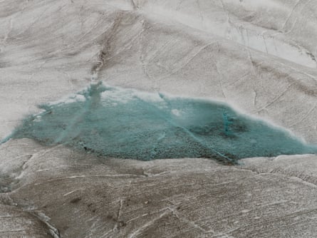 A blue pool of meltwater in a hollow of the glacier