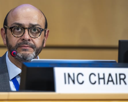 Luis Vayas Valdivieso sits next to a sign that reads ‘inc chair’