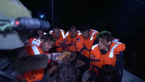 An Israeli solider passes food to those onboard the Gaza-bound British-flagged yacht "Madleen" after Israeli forces boarded the charity vessel as it attempted to reach the Gaza Strip in defiance of an Israeli naval blockade, in this screengrab from video released by the Israeli authorities.