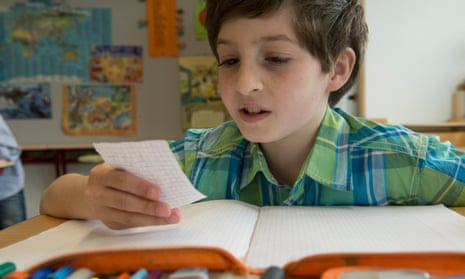 Schoolboy reading a message in classroom