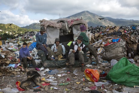 Men and boys at El Crematorio, the biggest dump on the outskirts of Tegucigalpa in Honduras, take a break from collecting plastic and cardboard to resell