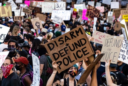 Protesters carry signs as they gather near city hall in Los Angeles on 3 June 2020.