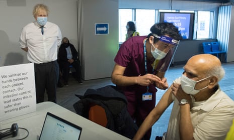 Boris Johnson watches a patient receiving a coronavirus vaccine shot
