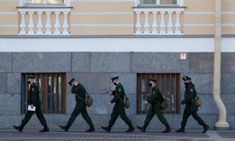 Russian soldiers wearing protective face masks walk along the Dvortsovaya square in St Petersburg.