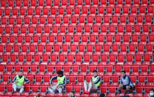 Bayern Munich substitutes await in the stands.