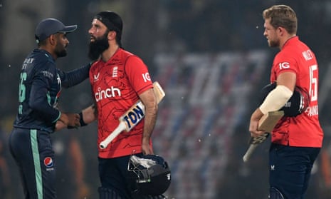 Pakistan's captain Babar Azam (left) shakes hands with his England counterpart Moeen Ali as England's David Willey looks on at the end of their fifth T20 international cricket match.