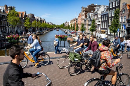 cyclists going both ways on a bridge over a canal
