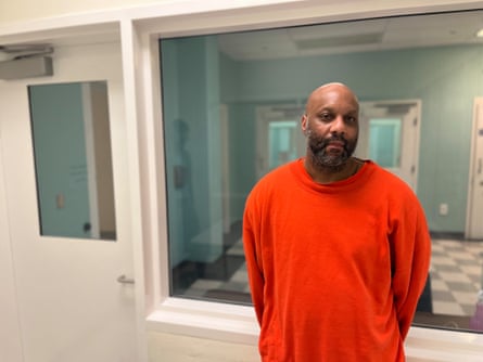 Black man in red shirt in white room