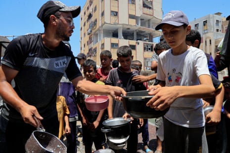 Palestinians gather to receive food from a charity kitchen in Nuseirat.