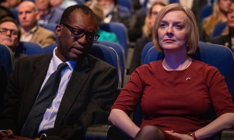 Kwasi Kwarteng bowing his head towards Liz Truss as she stares forward at the opening session of the Conservative party conference
