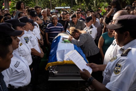 The funeral of Hugo, a police officer, in Santa Ana. His body was found on the street in Chalchuapa. He is survived by his wife and two children, a boy and girl.