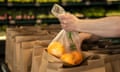 a worker puts oranges in a bag