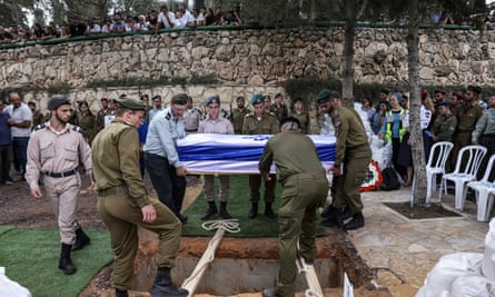Soldiers lower the casket of French-Israeli soldier Eli Valentin Ghenassia, who was killed in combat at the Be’eri kibbutz.