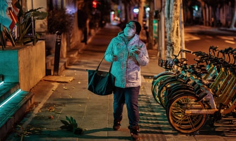 A woman walks on a deserted street in Shanghai, China, on 17 December, as recent official figures show a relatively low number of new daily Covid cases.
