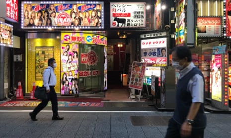 Two young men kissing, in the middle of tokio, night