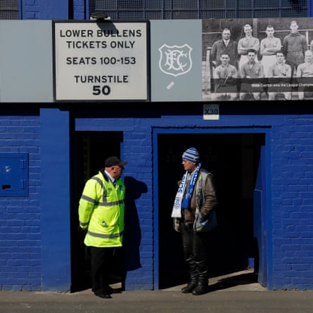 An Everton fan chats to a steward outside a turnstile on Bullens Road