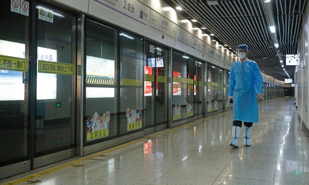 A rail staff member in a protective suit on duty at a subway station in Shanghai, China, as four of the city’s rail lines resumed service on Sunday