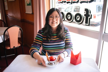 Presenter Jennifer Wong, in a colourful striped shirt, sitting at a white-clothed table with a bowl of deep-fried ice-cream.