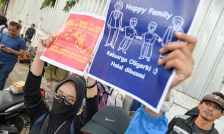 A protester in Indonesia holds a poster which reads “Oligarchic families should be lawfully eradicated”.
