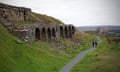 Walkers pass by the the disused 19th-century ironstone Kilns at Bank Top near Rosedale Abbey in the North York Moors in North Yorkshire in England.