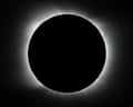 The moon completely covers the sun, with the solar corona illuminating the moon's edge
