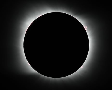 The moon completely covers the sun, with the solar corona illuminating the moon's edge