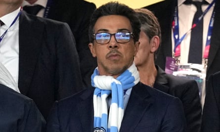 Sheikh Mansour bin Zayed Al Nahyan in the Manchester City crowd wearing a blue and white club scarf