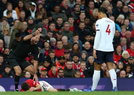 Daniel James of Manchester United lies injured as Virgil van Dijk looks on.