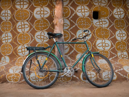 Bicycle rests against decorated exterior of a village house