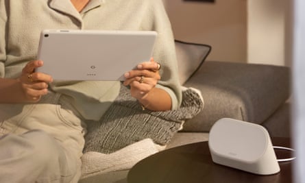 A woman holds the Google Pixel Tablet on a sofa.