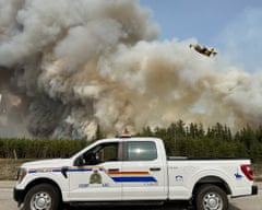 A Royal Canadian Mounted Police vehicle near a wildfire burning in Manitoba province.